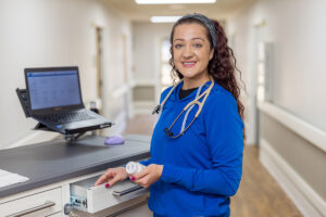 a nurse at a nurse's cart in the hallway at the West Village facility