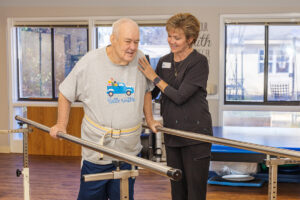 A rehab therapist with a resident in the rehab gym at the West Village facility