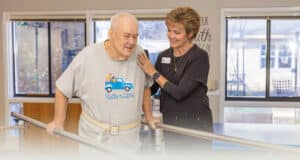 A rehab therapist with a a resident in the rehab gym at West Village Care