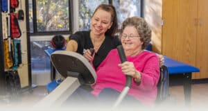 A rehab therapist with a a resident in the rehab gym at West Village Care